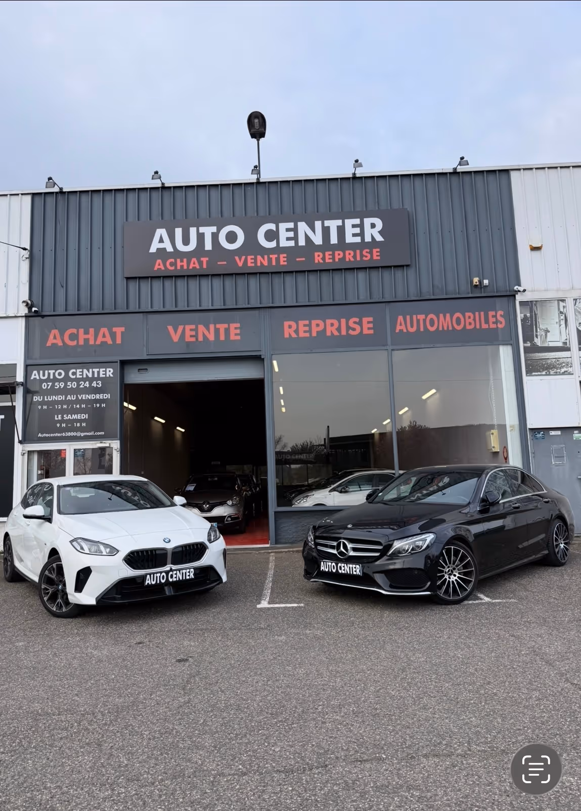 Vue de la façade du garage AUTOCENTER avec plusieurs voitures exposées.